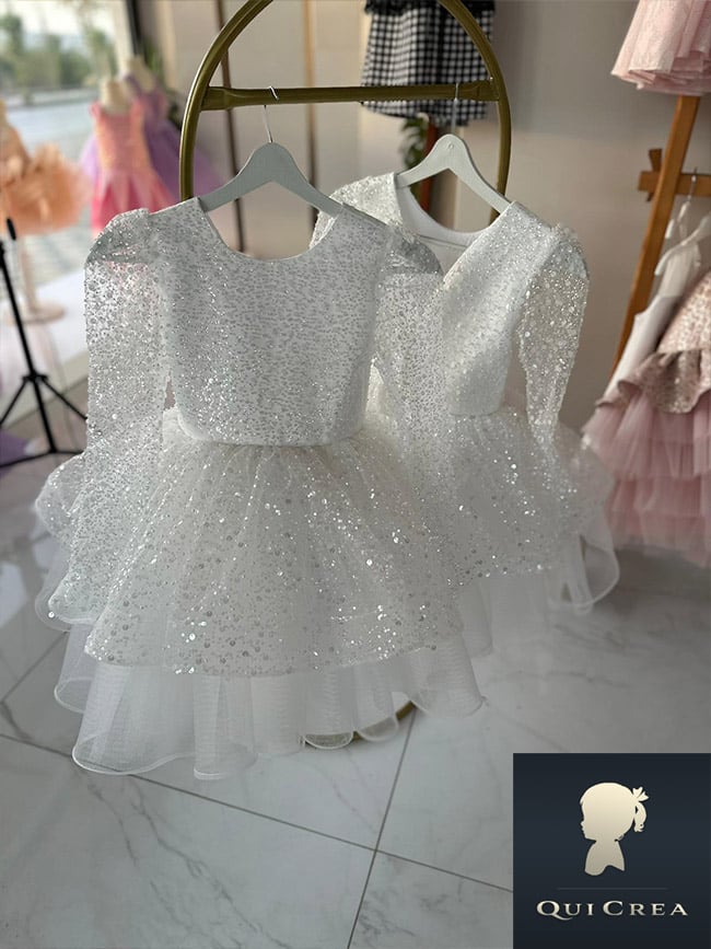 Abiti eleganti bambina esposti in showroom per eventi speciali.