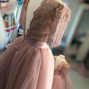 Frange eleganti sulle maniche dell'abito da cerimonia per bambina.