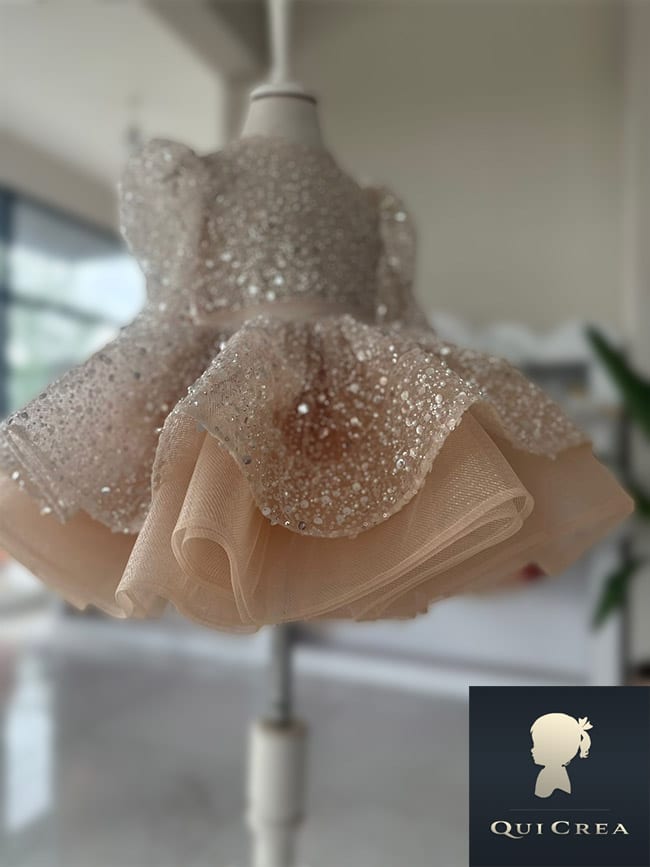 Dettaglio del vestito in tulle per bambina con perle e paillettes